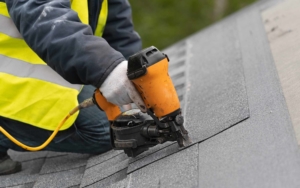 Close up view of a roofer nailing in a shingle