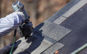 Close up view of roofing worker using nail gun
