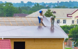 Group of commercial roofing workers installing a metal roof