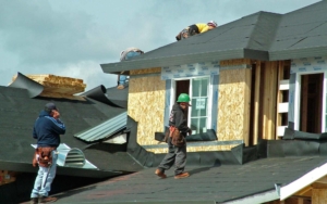 Group of roofing workers installing a new roof on a home