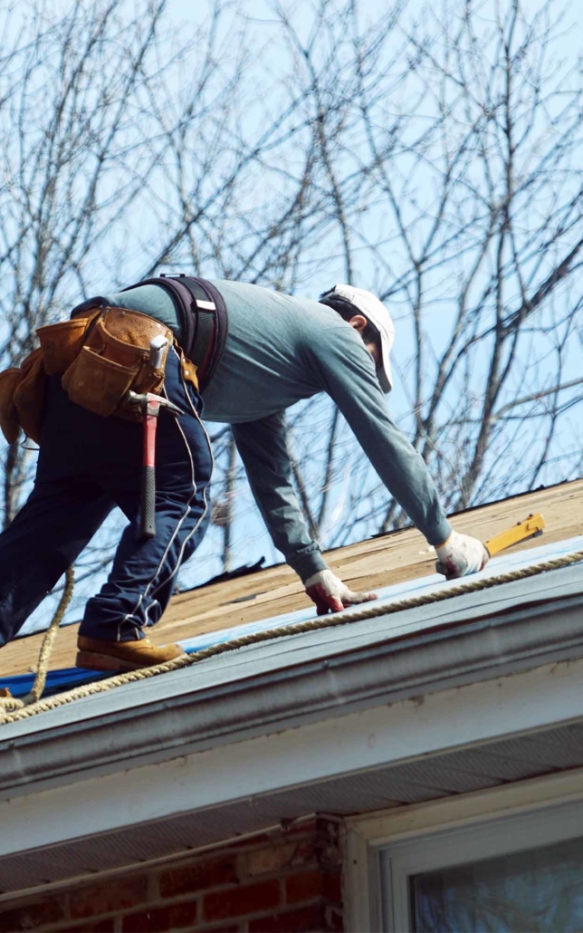 Roofing worker making repairs to a residential house vertical