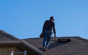 Roofing worker walking up the front of a house