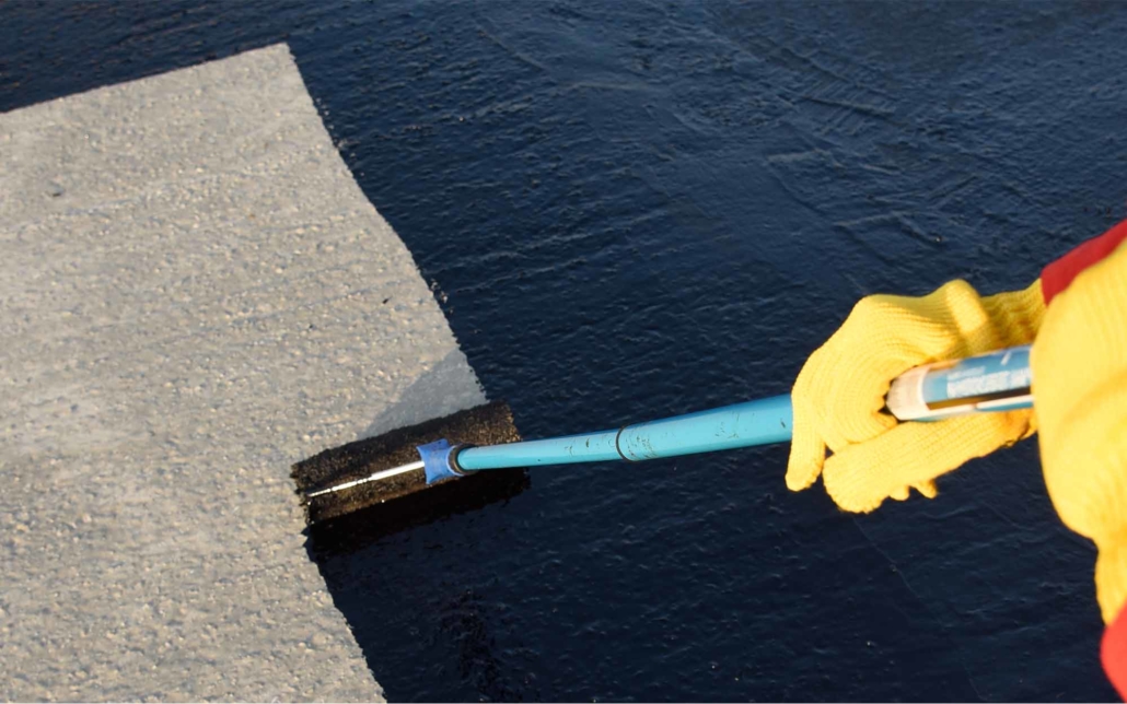Roofing worker using a roller to add black TPO seal