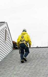 Roofing worker walking on roof performing an inspection