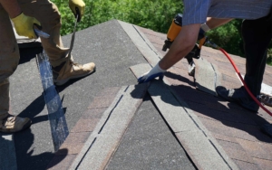 Roofing workers installing a new area of shingles