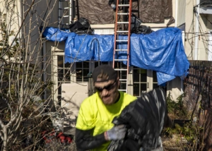Roofer removing tarp from roof
