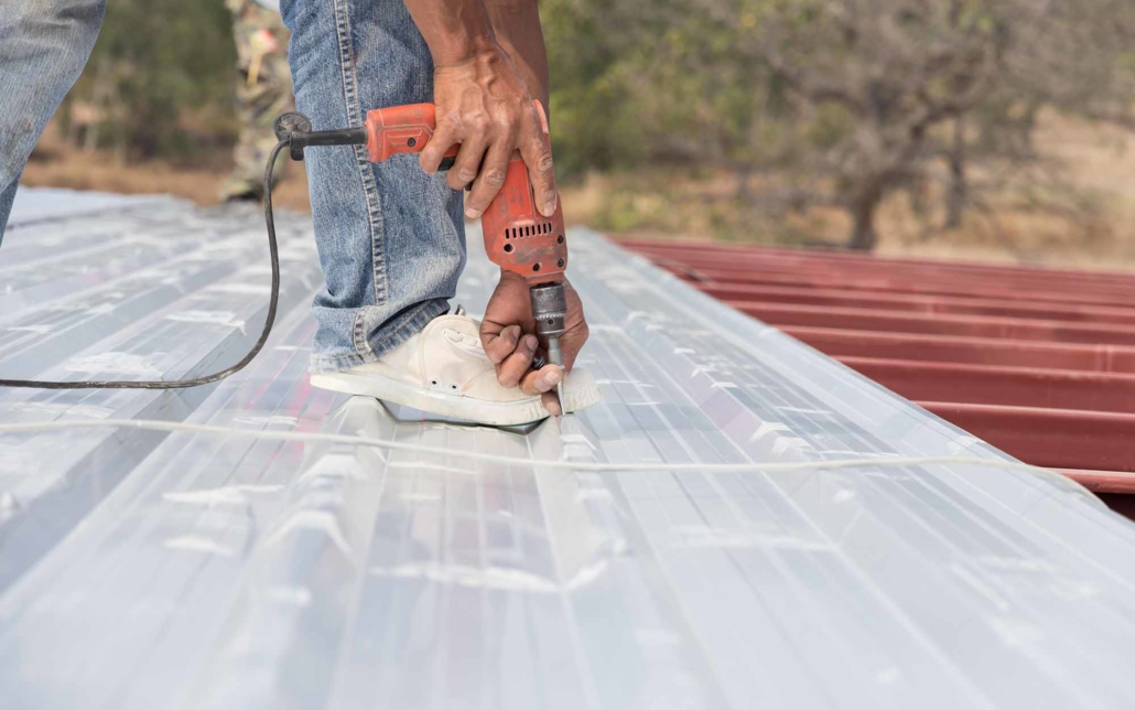 Close up ground level view of roofer installing metal roof