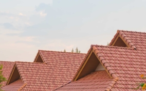 Close up of a Spanish-style roof with burnt orange shingles and sky in the background