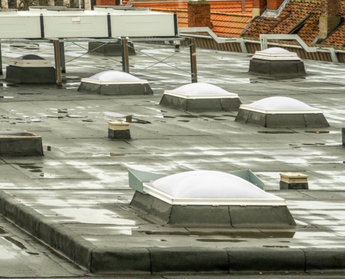 Image of rain water pooling ontop of a flat commercial roof.
